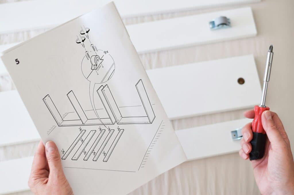Woman is reading instruction manual while assembling furniture